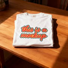 Folded tee on wooden tabletop with styling props